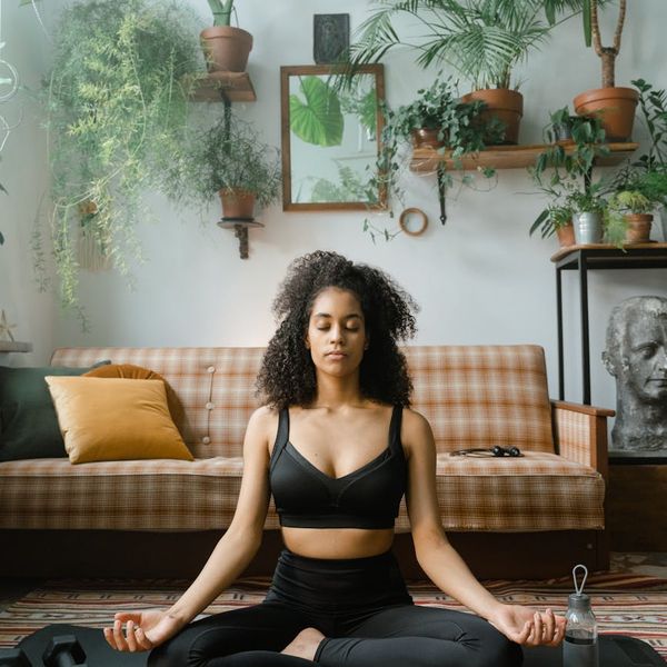 A clean and peaceful space ready for a yoga practice, with a mat and some plants.